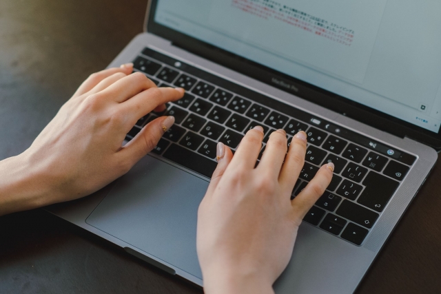 MacBook Proでタイピングする女性の手元